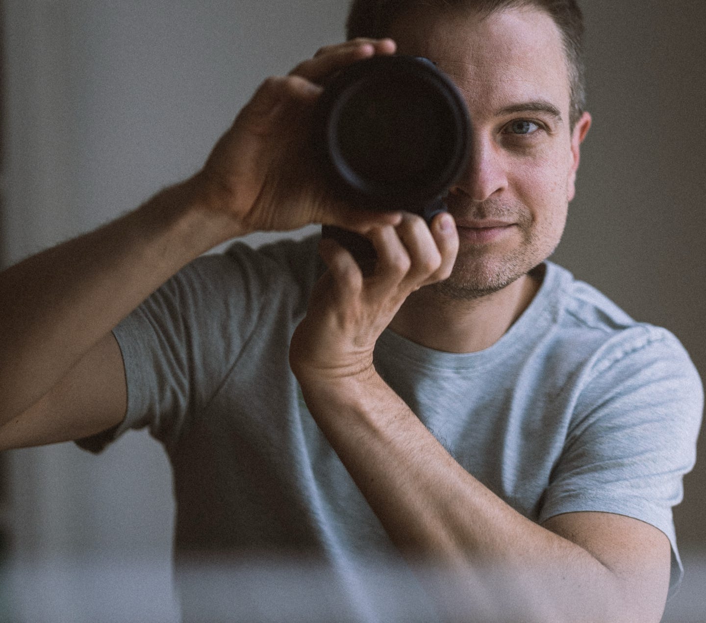 Person, die mit einer professionellen Kamera die Natur in einer winterlichen Umgebung einfängt.